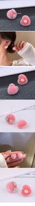 Close-up detail of pink flocked peach stud earrings with green leaf accents and velvet texture