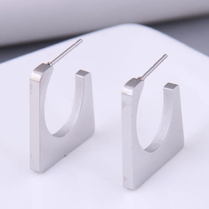 Detail of silver geometric square stud earrings in minimalist polished stainless steel