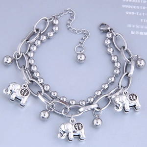 Detailed view of silver double-layer bracelet with elephant charms and small bells