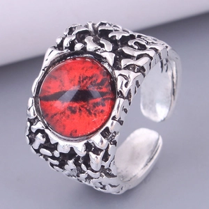Macro shot of gothic evil eye ring with red pupil and vintage silver scale texture