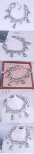 Detail view of double-layer steel bracelet with silver beads and lucky money bag charms