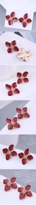 Detail view of burgundy enamel flower stud earrings with gold plating and beaded center