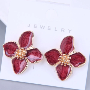 Elegant burgundy enamel flower stud earrings with golden textured centers on a white card