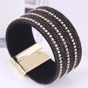 Détail macro du bracelet large en cuir noir avec cristaux et fermoir magnétique doré
