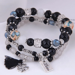 Detailed view of bohemian triple-layer beaded bracelet with silk tassel and Love charm