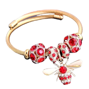 Golden wire rope bracelet with bee pendant and sparkling red white rhinestones