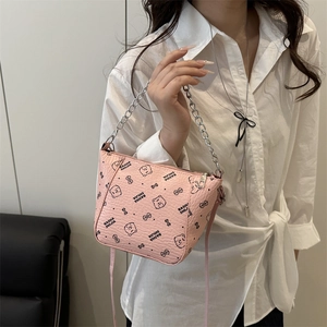 Pink crossbody bag with bear pattern and silver chain strap shown on model