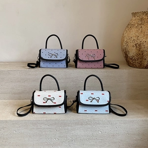 Mini crossbody bags with heart and bow patterns featuring elegant metal bow clasps