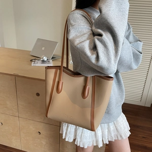 Minimalist beige and brown leather tote bag for women shown in a lifestyle office setting