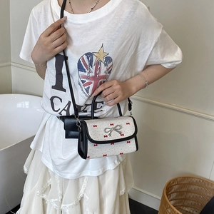 Chic women's crossbody bag with bow patterns and a silver metallic bow clasp