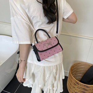 Polka dot bow handbag in pink stripes with black heart patterns and metallic bow detail