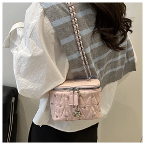 Dettaglio borsa box trapuntata rosa con borchie argento, catena e ciondolo rosa