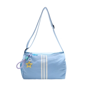 Light blue cylinder crossbody gym bag with white stripes and star charm on white background