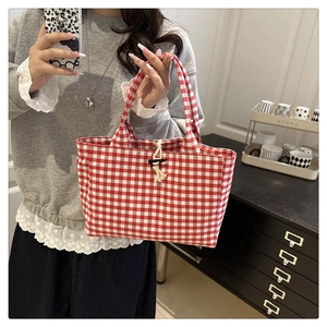 Détail du sac cabas en toile vichy rouge avec un bouton bascule en bois rustique
