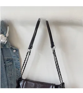 Detail of dark brown wrinkled texture leather shoulder bag with chain strap
