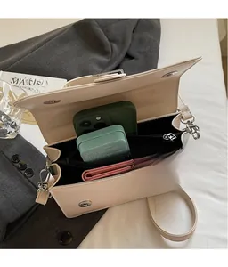 Detail view of the beige crossbody bag interior showing spacious compartments and storage