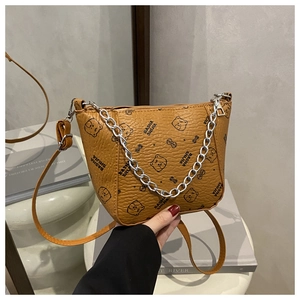 Détail d'un sac seau marron en cuir avec motif d'ours et chaîne en argent chic
