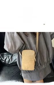 Detail view of khaki nylon mini shoulder bag showing front pocket and zipper hardware