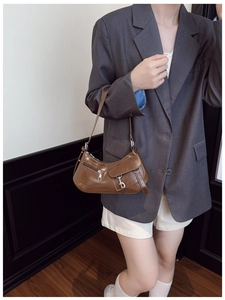 Détail du sac porté épaule vintage en cuir verni marron avec zip métallique et crochets