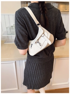 Vue détaillée d'un sac sous le bras crème en demi-lune avec boucles rétro et poche latérale