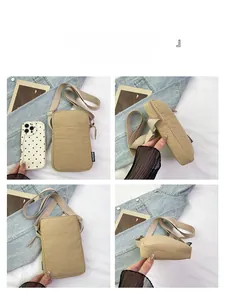 Detail view of the beige mini crossbody phone bag with adjustable strap and zip closure