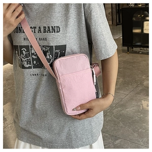 Pink mini crossbody phone bag shown with adjustable shoulder strap and fashion label