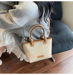 Detail der gewebten Beuteltasche mit braunem Lederbesatz und Fashion & Bags Lederetikett