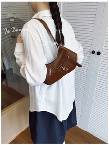 Détail du sac sous l'aisselle marron avec boucles argentées et silhouette croissant rétro