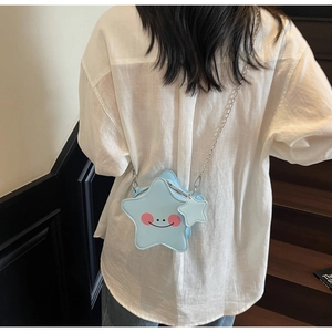 Dettaglio della borsa a tracolla azzurra a forma di stella con smiley e catena d'argento