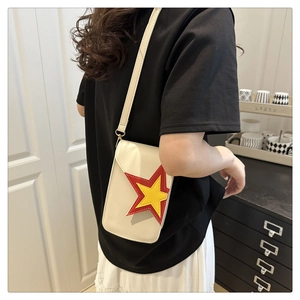 Détail d'un petit sac bandoulière blanc en cuir avec motifs étoiles rouges et jaunes