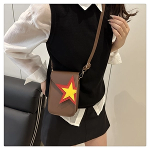 Détail du sac bandoulière en cuir marron avec motif étoile bicolore et boucles dorées chic