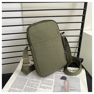 Detail of olive green nylon crossbody bag with textured fabric and fashion side label