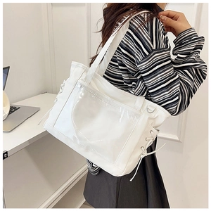 Close-up of the white ita bag featuring a clear PVC window and side drawstring details