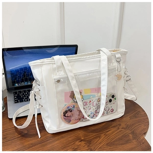Detail of white PU tote bag with a clear PVC window for doll display and side laces