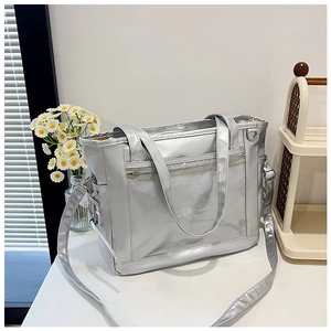 Macro detail of silver tote bag featuring a clear PVC window and lace-up side design