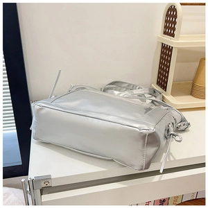 Close-up of silver metallic tote bag featuring side bow ribbons and a glossy finish