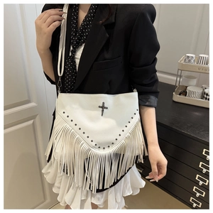 Détail du sac punk blanc clouté avec des franges bohèmes et logo croix métallique