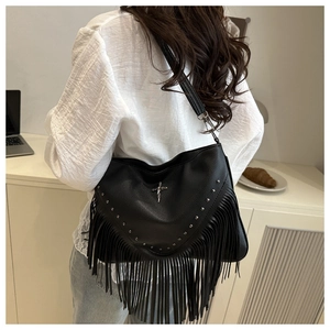Détail du sac à franges en cuir noir grainé avec rivets argentés et croix métal