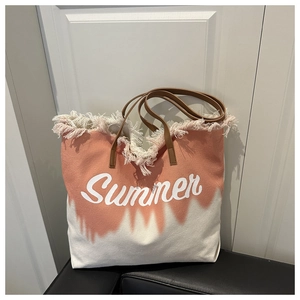 Detail of pink tie-dye canvas tote bag with fringed edges and Summer lettering