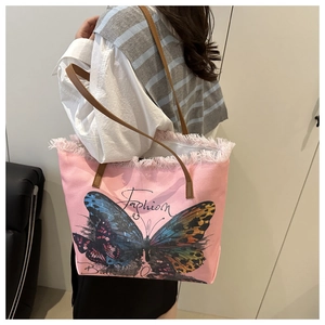 Close-up of pink canvas tote bag showing fringe edges and artistic butterfly print