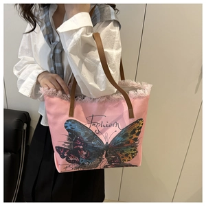 Detail of pink canvas tote bag featuring floral butterfly print and stylish fringe edges