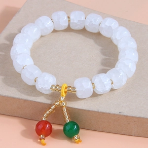 Détail d'un bracelet en résine avec perles blanches effet givré et pendentifs colorés