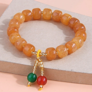 Détail du bracelet en perles de résine orange avec perles en forme de barillet avec nœuds colorés