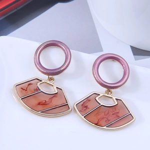 Detailed macro view of geometric fan-shaped earrings with purple and amber resin textures