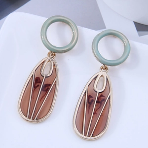 Detail of geometric hexagon earrings with turquoise studs and amber resin pendants