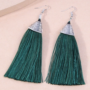Detail of bohemian long dark green silk tassel earrings with vintage silver floral caps