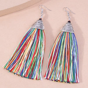 Detailed shot of ethnic style silver earrings with vibrant multi-colored silk tassels