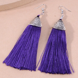 Detail of deep purple long tassel earrings with silver alloy embossed floral caps