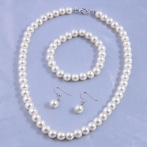 Elegant white pearl jewelry set featuring necklace, bracelet and drop earrings with silver clasps