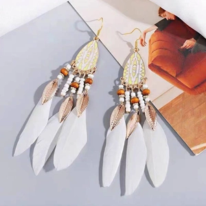 Bohemian feather drop earrings with metal leaves and beads on a stylish background